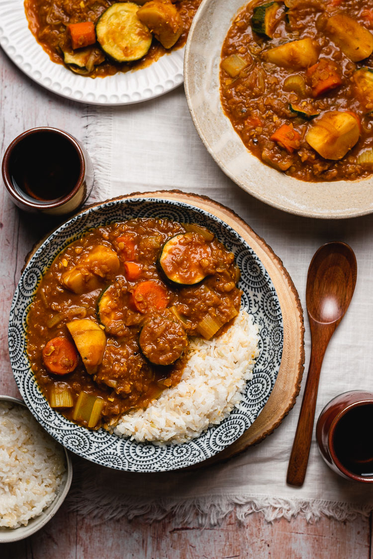 vegan japanese curry served in bowls with rice and tea on the side