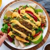 hand reaching for loaded vegan nachos