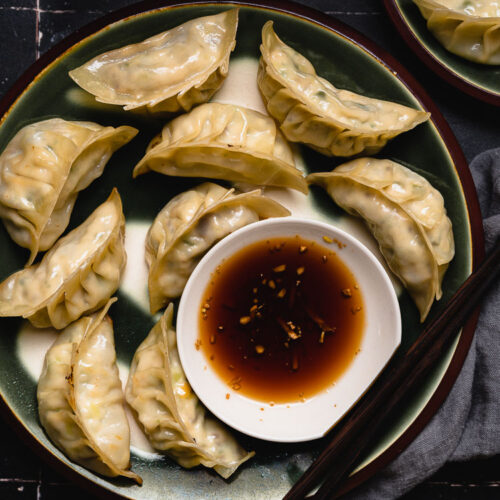 tofu gyoza on a plate with dipping sauce