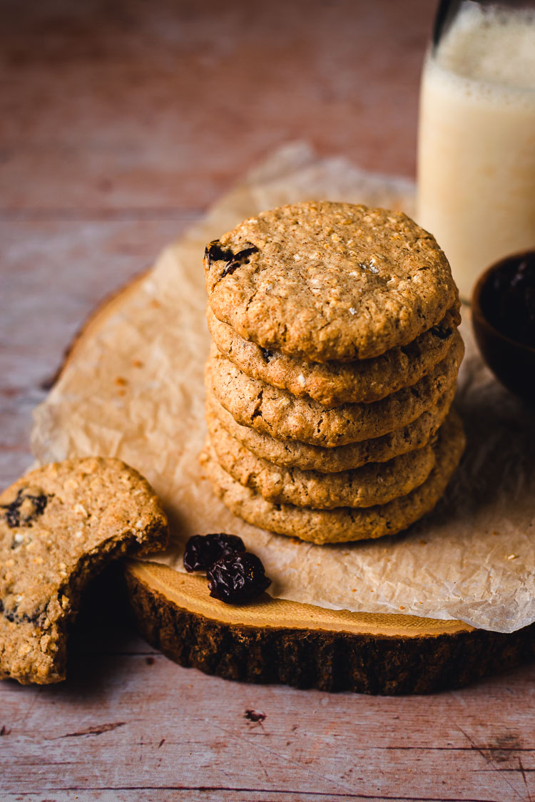 stack of chewy oatmeal raisin cookies with a bite taken out of one cookie on the side