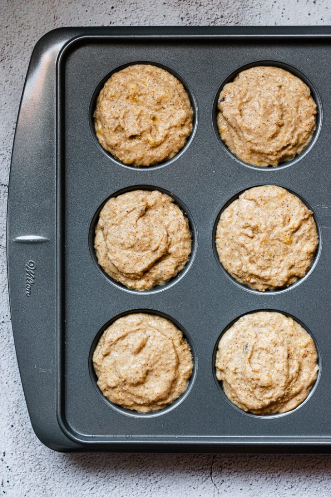 vegan sesame banana muffin batter in muffin pan, right before baking