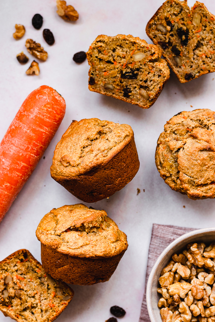 flatlay of vegan carrot banana muffins with carrot, walnuts, and raisins