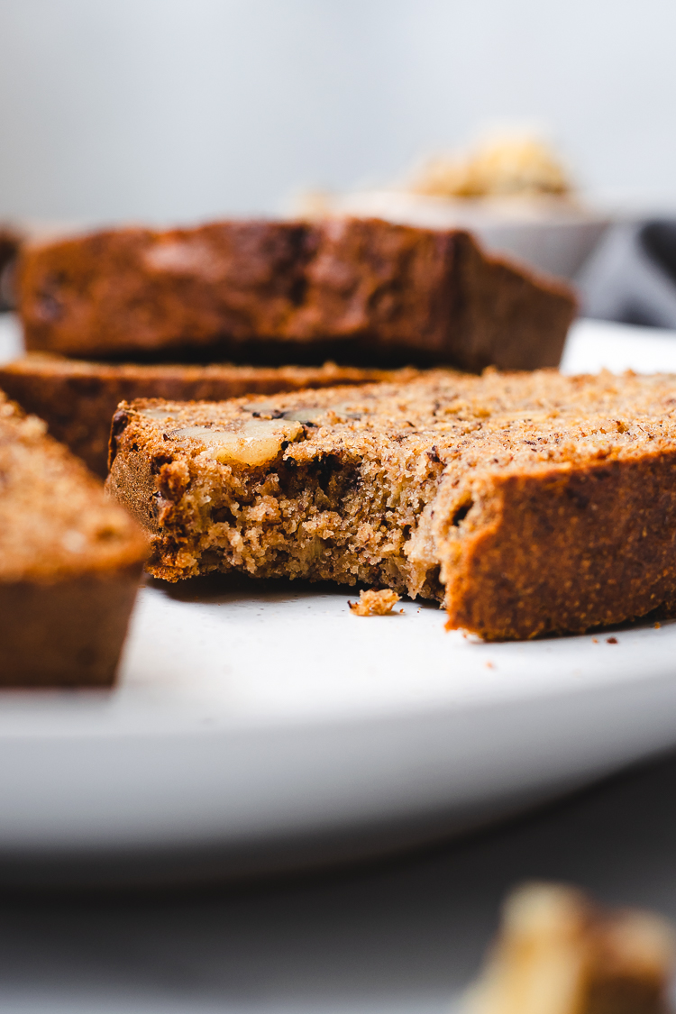 slice of vegan banana bread with a bite taken out of it