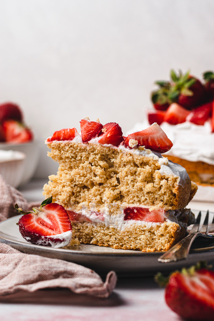 a slice of vegan strawberries and cream cake on a plate