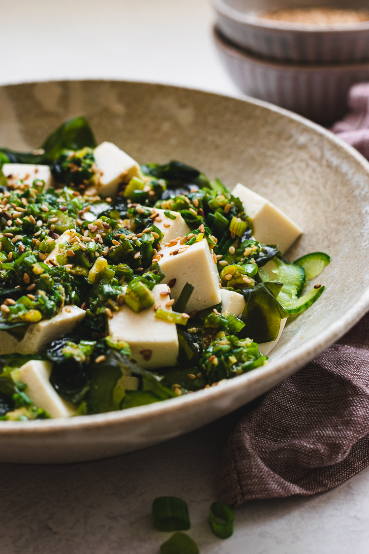 close up of tofu and green onion salad in a plate