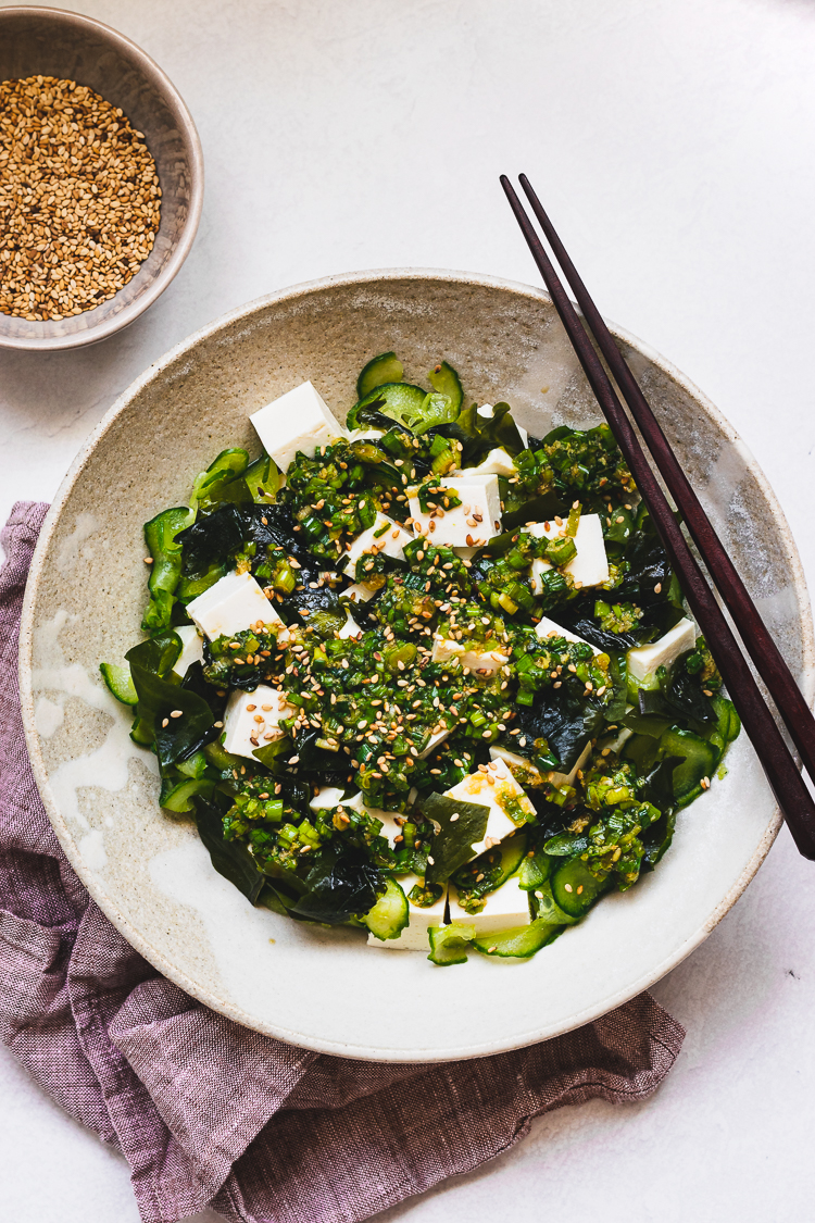 overhead shot of tofu and green onion salad in plate with chopsticks