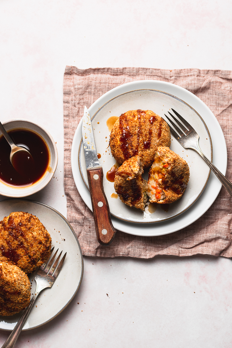 flatlay of vegan white bean korokke on a plate with one korokke cut in half