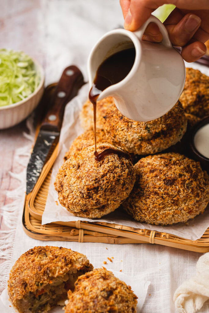 worcestershire sauce poured over korokke on a plate