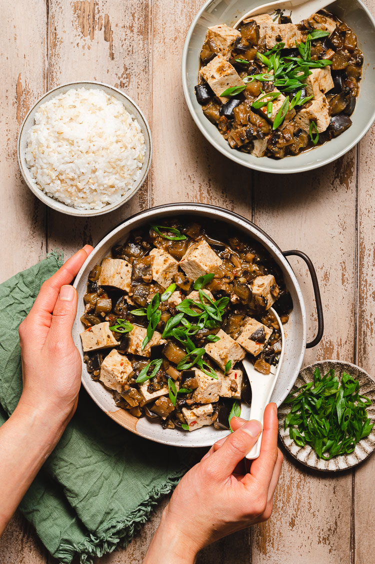 hands holding bowl of mapo tofu