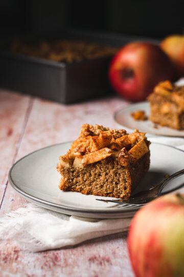 a piece of vegan apple crumb cake on a plate with a fork
