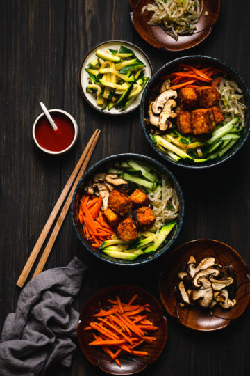 two bowls of tempeh bibimbap with fillings on the side