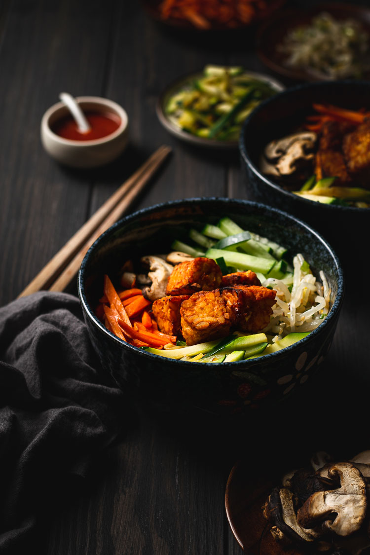 vegan bibimbap bowl with ingredients in background