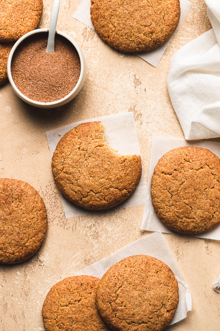 vegan gluten free snickerdoodle flatlay with a bite taken out of one cookie