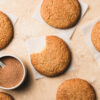 vegan gluten free snickerdoodle with a bite taken out of it, surrounded by more snickerdoodles