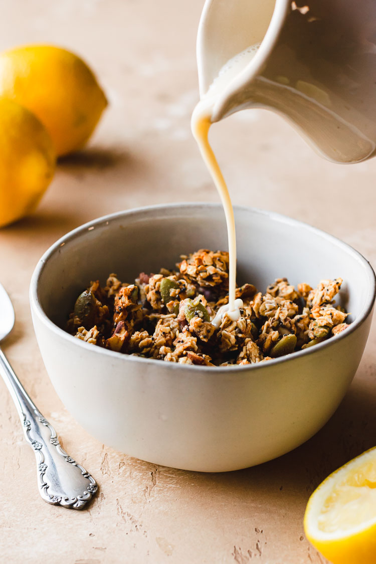 milk being poured in to a bowl of granola