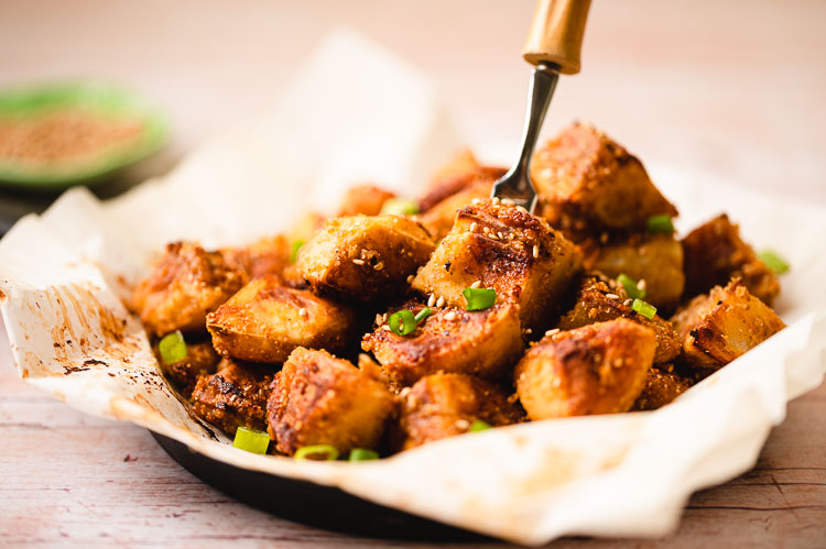 sesame miso potatoes in a skillet with a fork piercing one