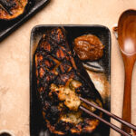 chopsticks scooping out flesh of miso eggplant