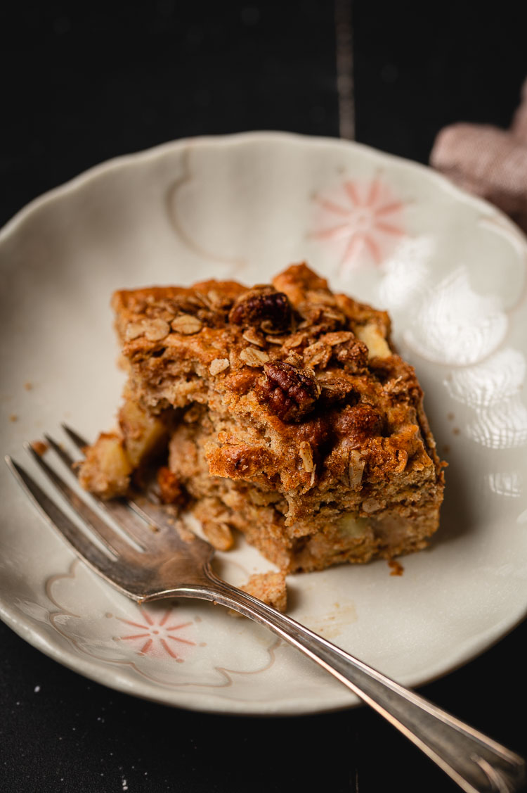 slice of apple coffee cake on a plate with a bite taken out of it