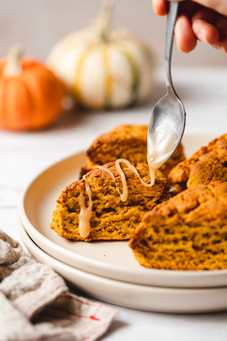 maple glaze being drizzled on pumpkin scone