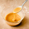 vegan caramel sauce dripping off a spoon