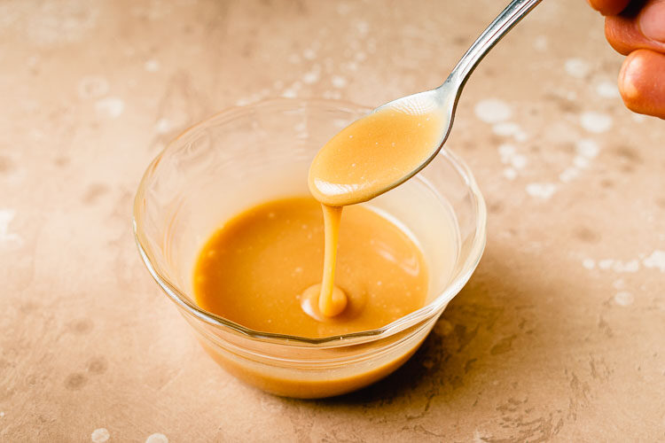 vegan caramel sauce dripping off a spoon