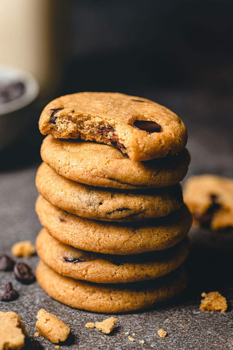 stack of chocolate chip cookies with a bite taken out of the top cookie