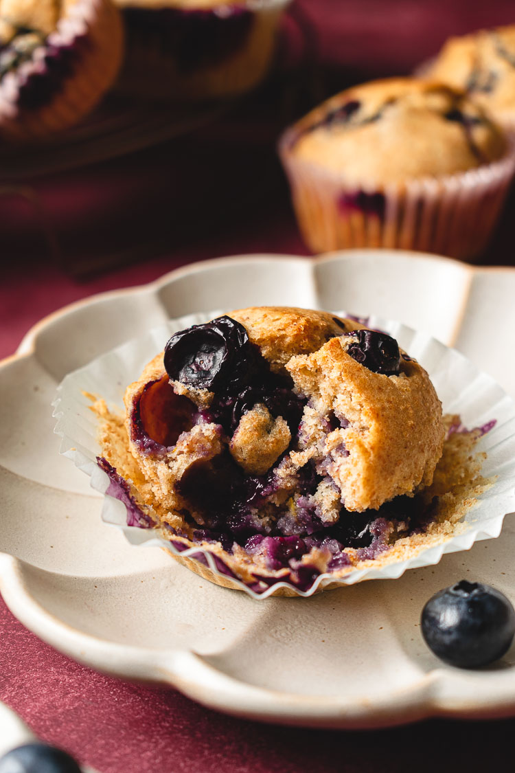 blueberry muffin on a plate with bite taken out of it