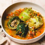 vegan cabbage rolls in a plate, cut in half