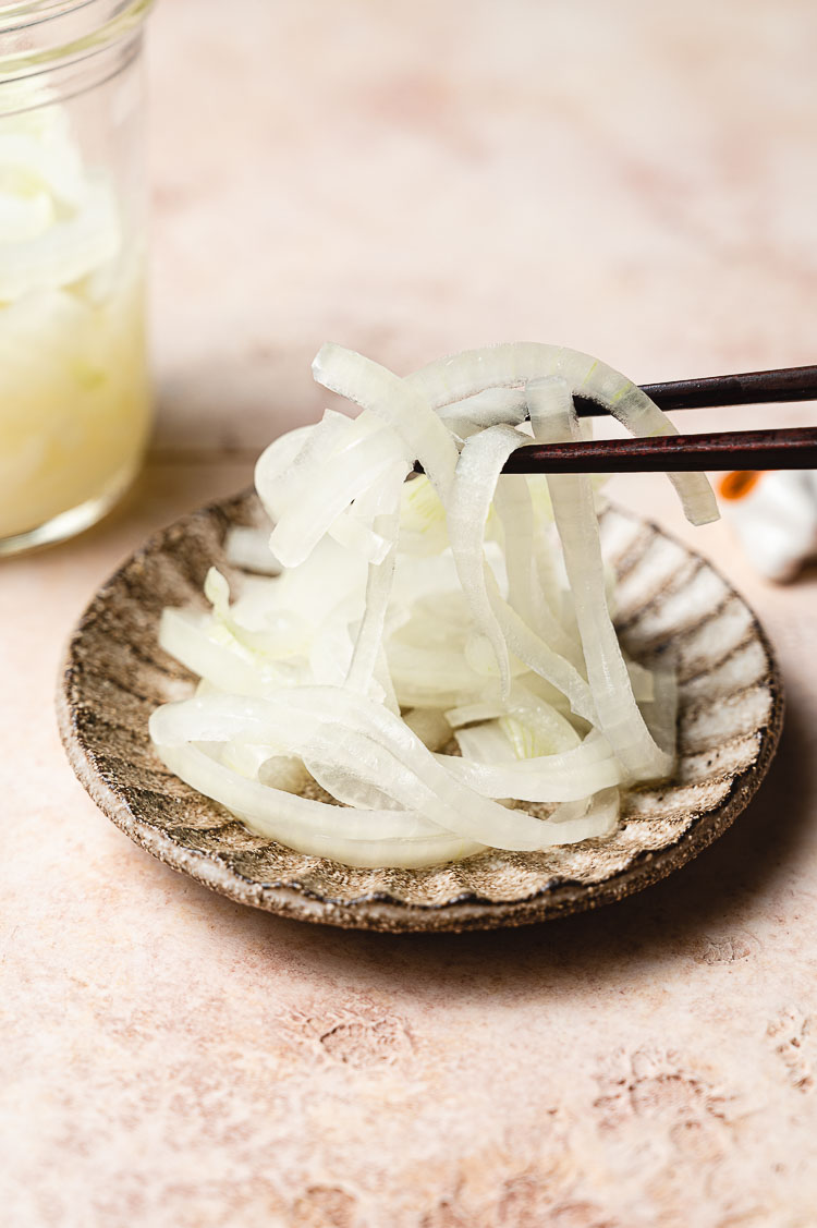 chopsticks picking up some pickled onions