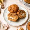 vegan carrot cake muffins on a plate, one cut in half