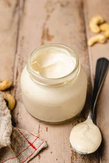 vegan cashew mayo in a jar with a spoonful next to it
