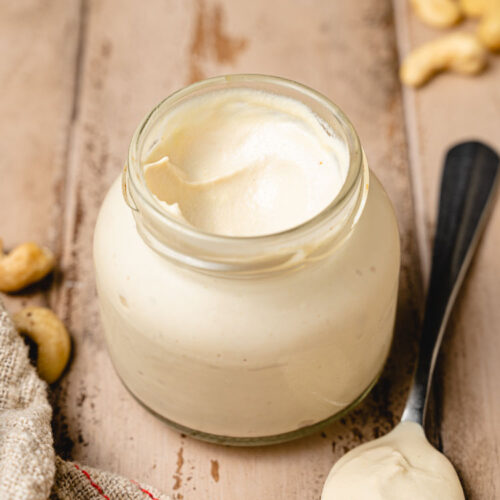 vegan cashew mayo in a jar with a spoonful next to it