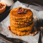 vegan pumpkin oat pancakes drizzled with maple syrup