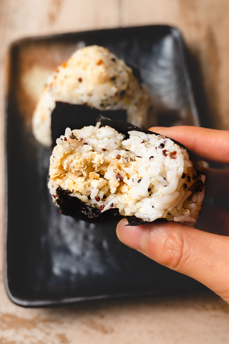 tuna mayo onigiri with a bite taken out of it