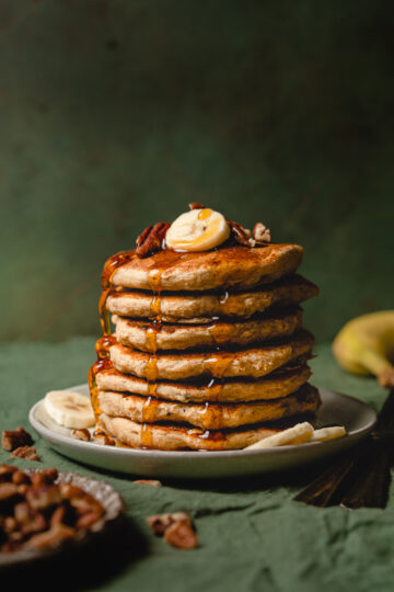 plate of vegan banana pancakes with maple syrup drizzle