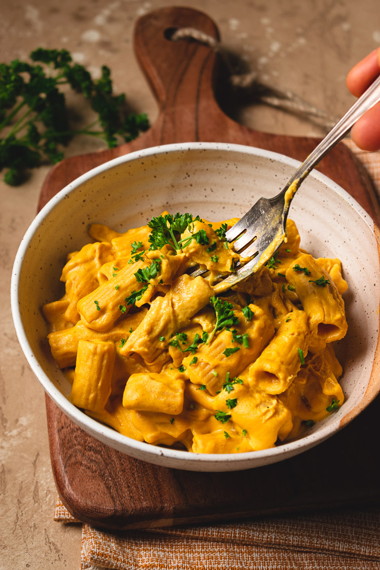 fork getting a bite of vegan mac and cheese in a bowl