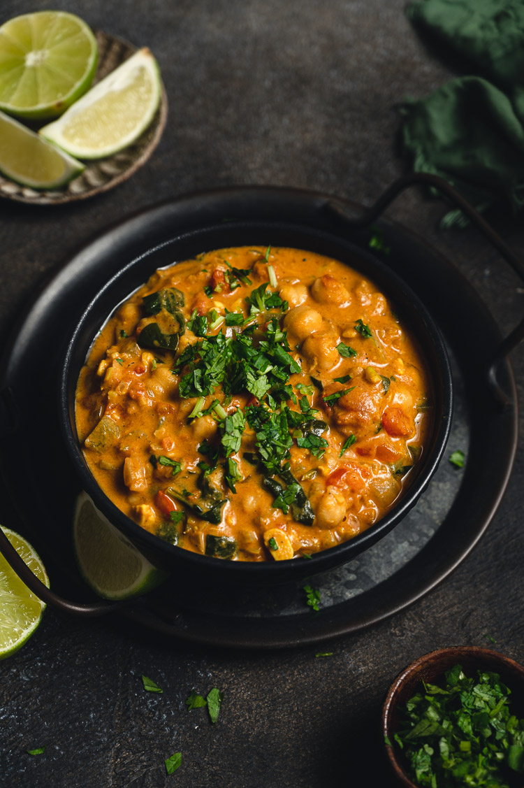 45 degree shot of a bowl of vegan peanut curry with chickpeas and tempeh