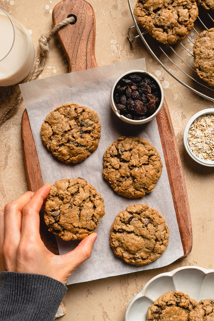 hand grabbing an oatmeal raisin cookie off platter