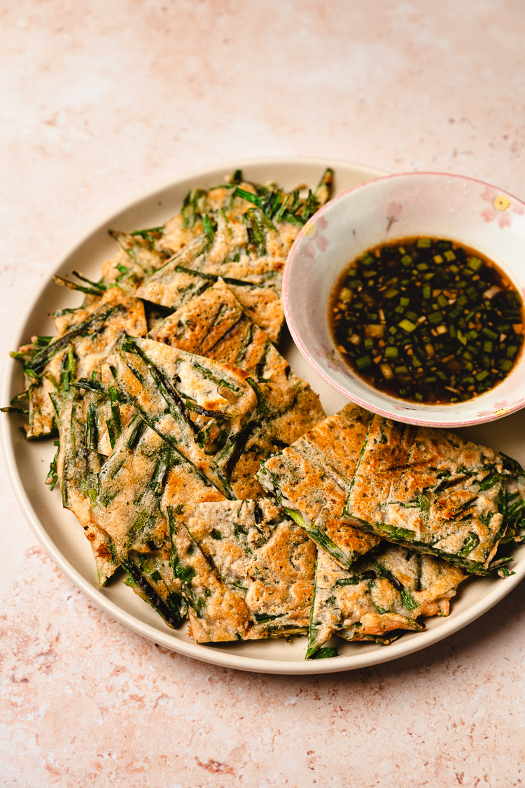 red lentil chive pancakes on a plate with dipping sauce