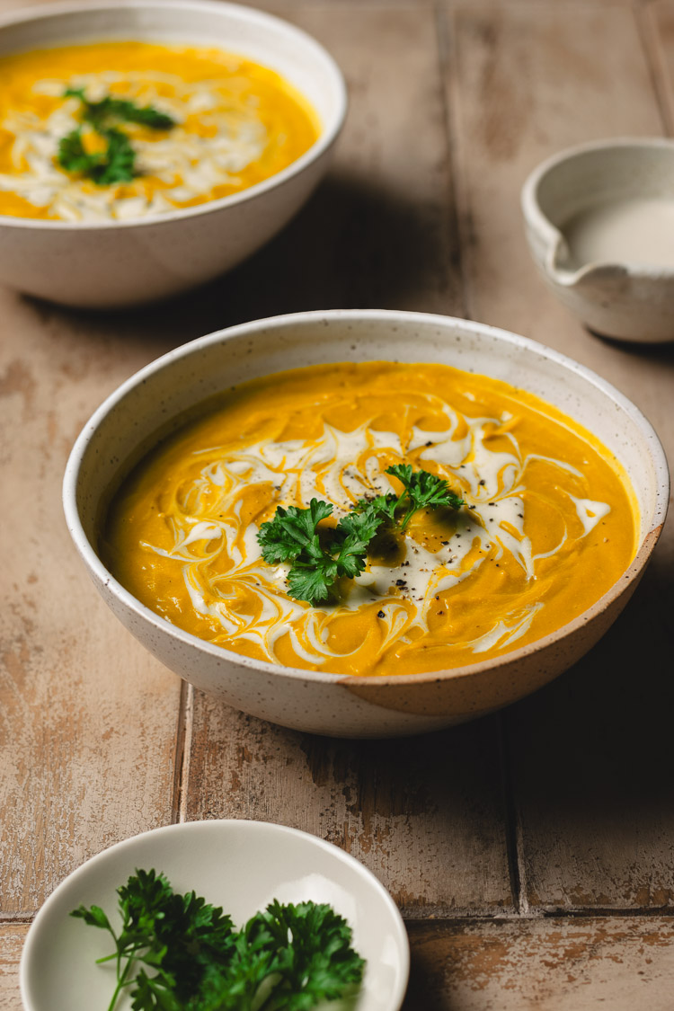 two bowls of red lentil kabocha soup