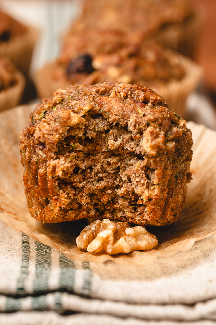 close up zucchini oatmeal muffin with a bite taken out of it