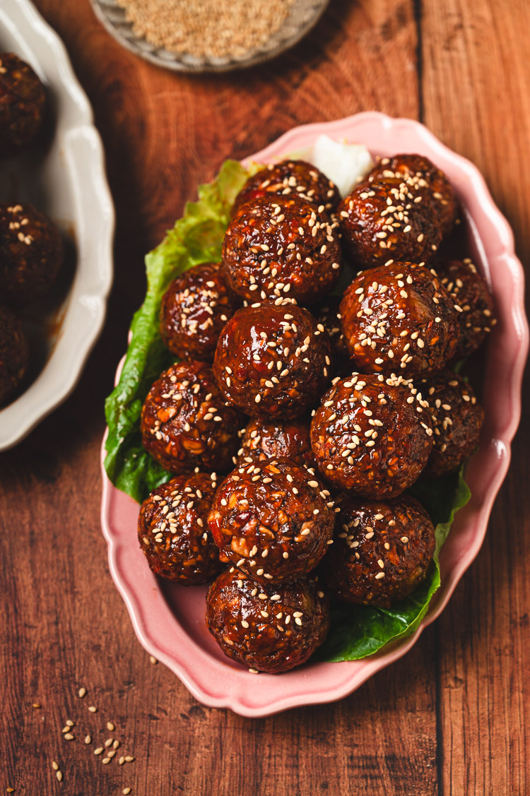 vegan sweet and sour meatballs on a plate sprinkled with sesame seeds