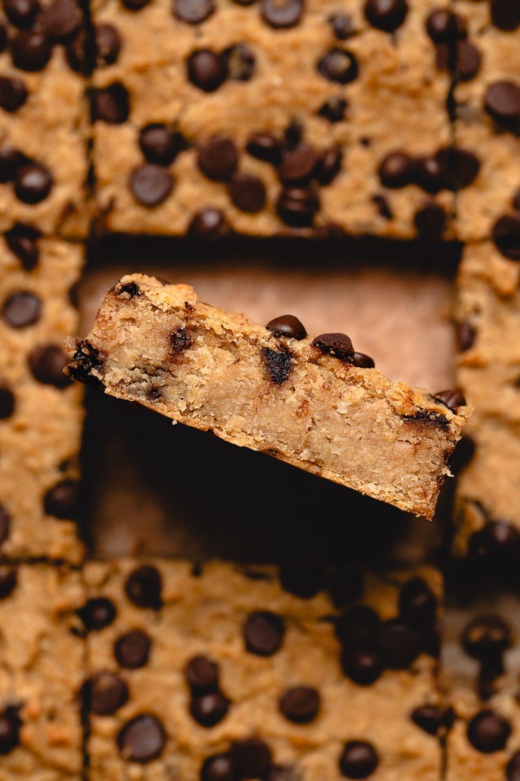 close up of chickpea blondies in pan, one blondie on its side