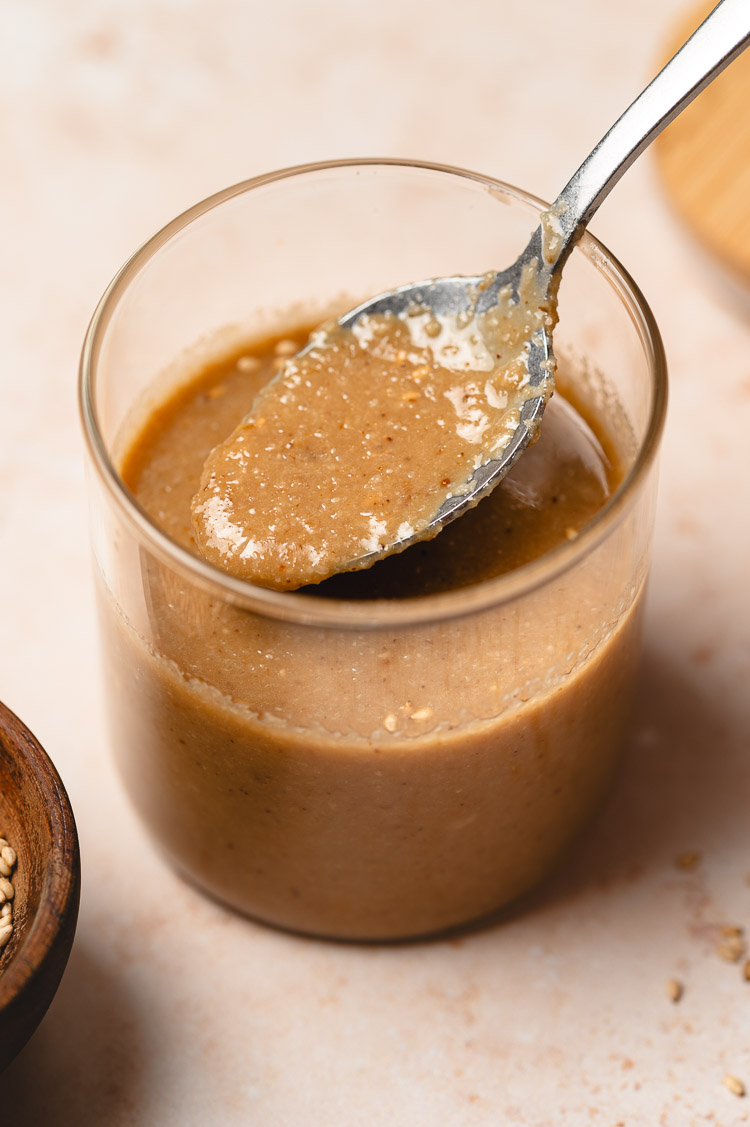 spoon reaching into a jar of japanese sesame dressing