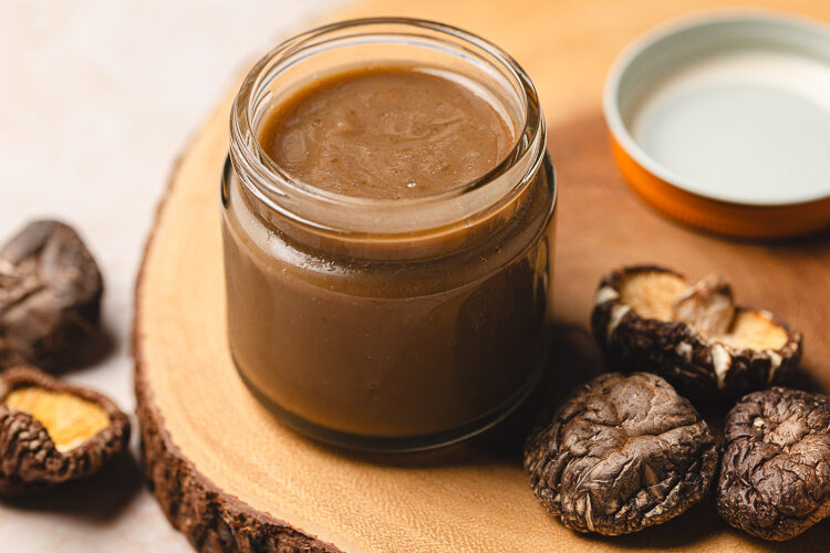 jar of homemade vegan oyster sauce surrounded by dried shiitake