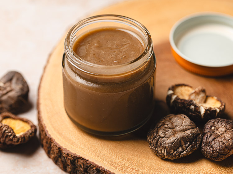 jar of homemade vegan oyster sauce surrounded by dried shiitake