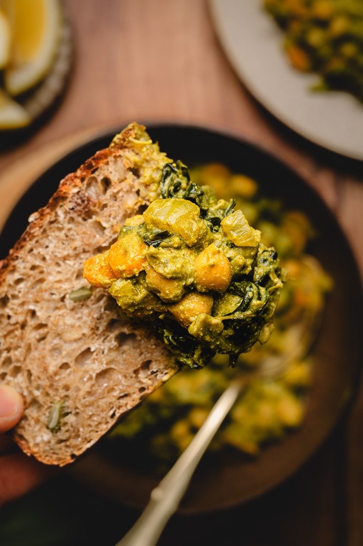 chickpea spinach curry on bread close up