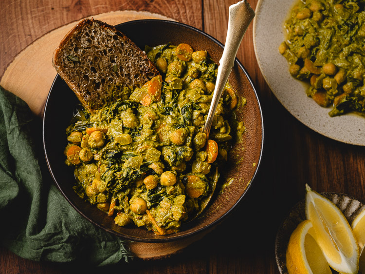 bowl of vegan chickpea spinach curry with bread