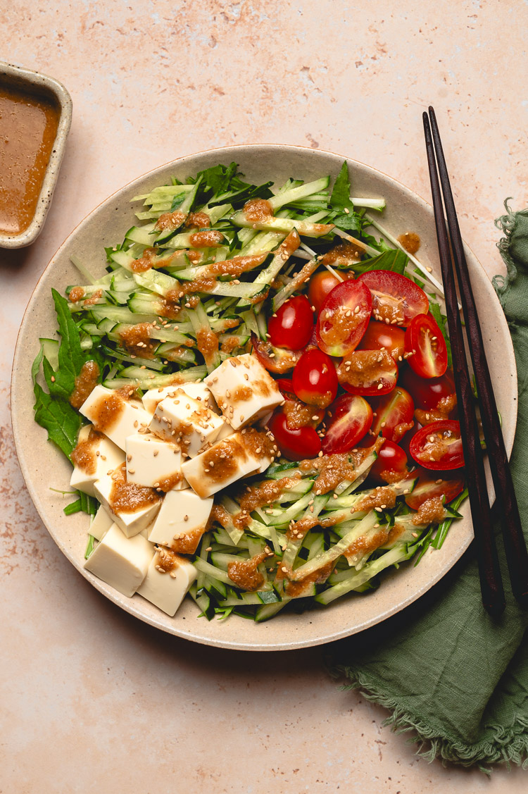 sesame mizuna salad on plate, dressing on the side