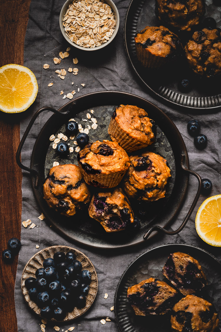 vegan blueberry oatmeal muffins flatlay with muffins on serving trays